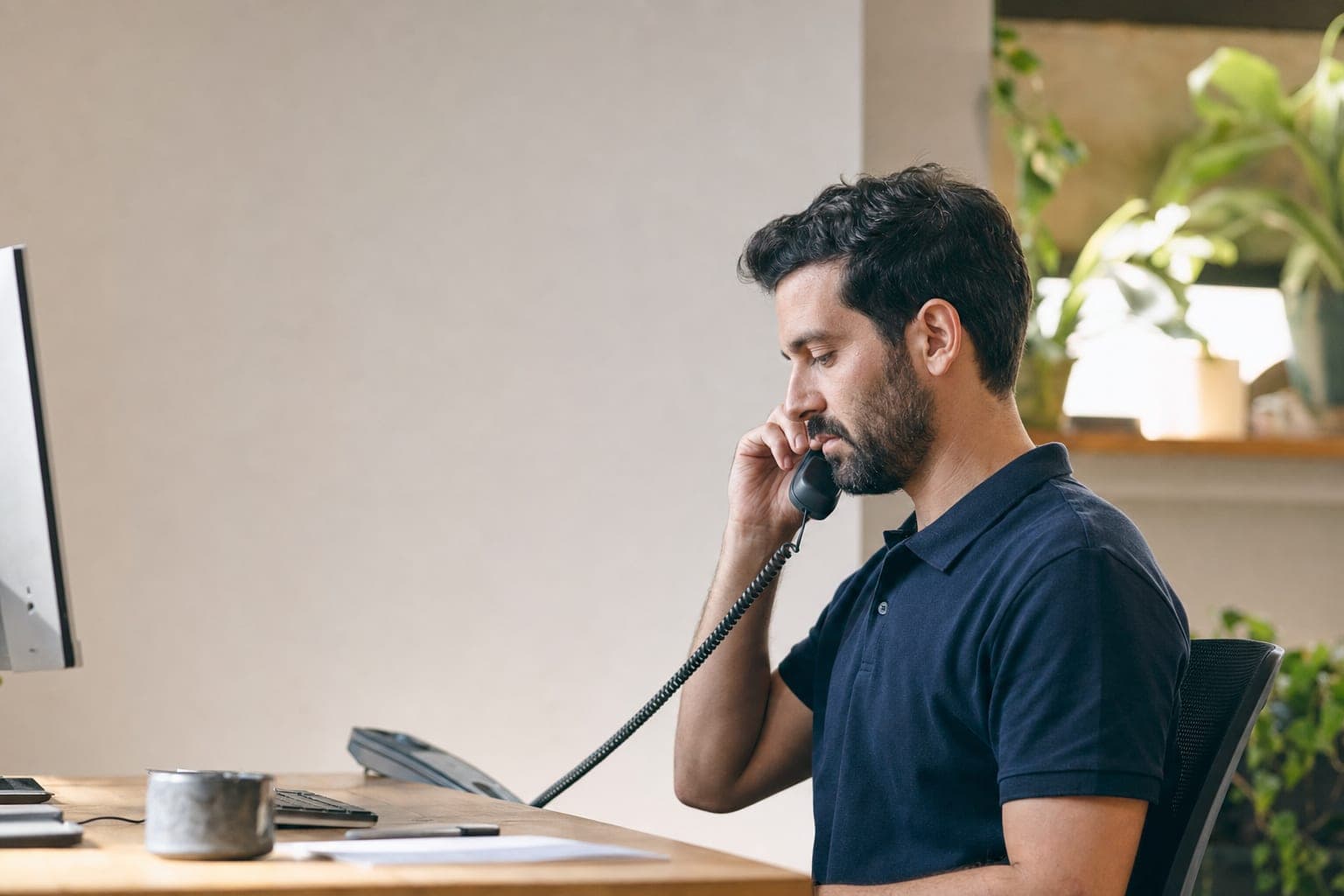 Mitarbeiterin im Telefonat am Schreibtisch, bereit für Ihr Erstgespräch